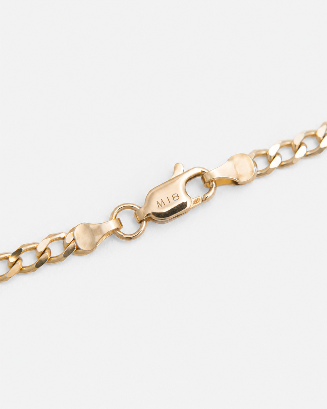 Primer plano del broche tipo langosta con grabado M18 en una pulsera de oro amarillo de 10 quilates, destacando el acabado pulido, el sistema de cierre y la calidad de fabricación.
