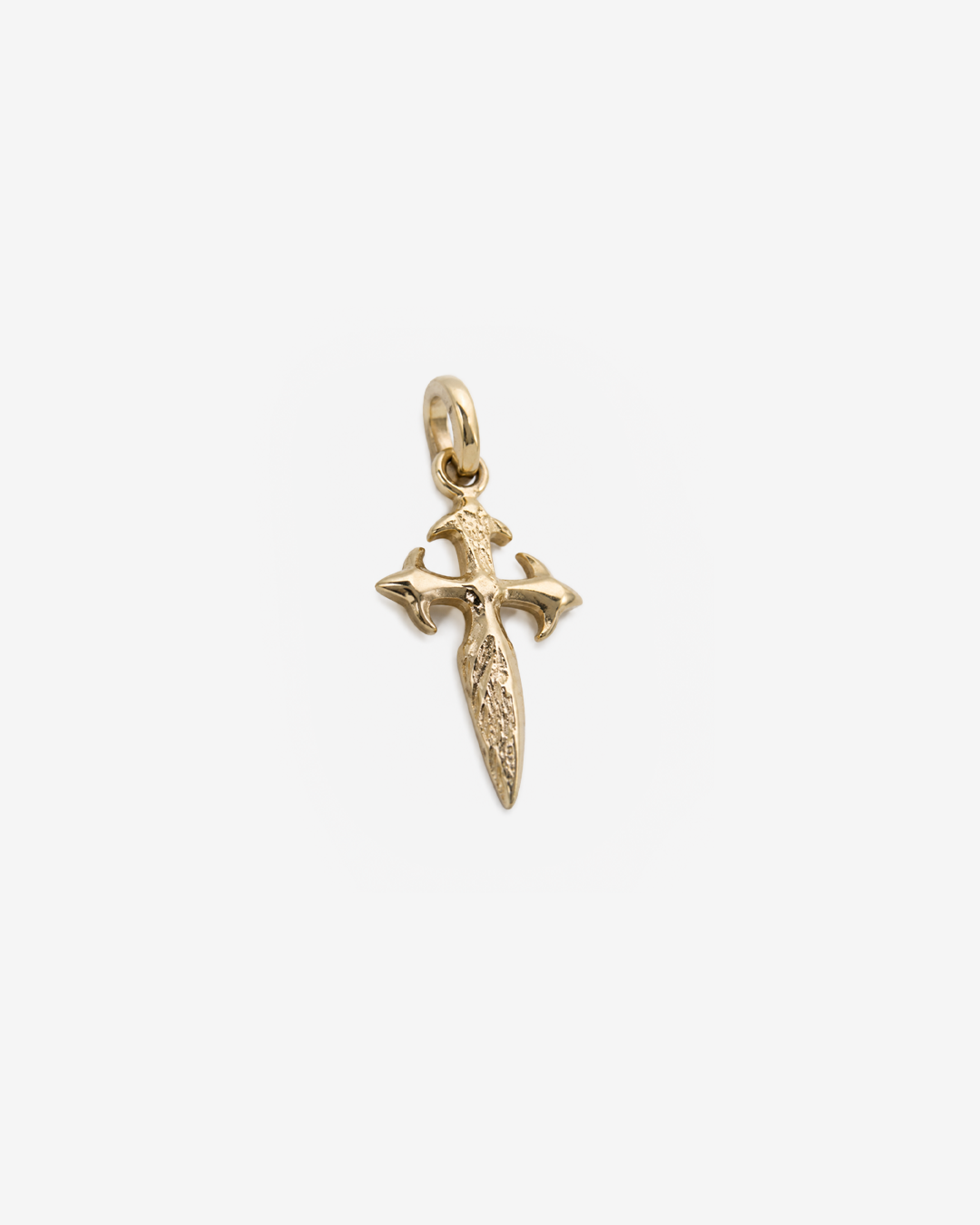 Dije de oro amarillo de 10 quilates en forma de cruz con diseño estilizado y acabado pulido, fotografiado de frente sobre un fondo blanco para destacar sus detalles.